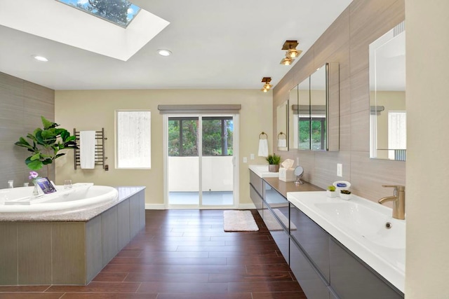 1710 Via Allondra, San Marcos, CA 92078 - bathroom with a skylight, wood finished floors, two vanities, a sink, and baseboards