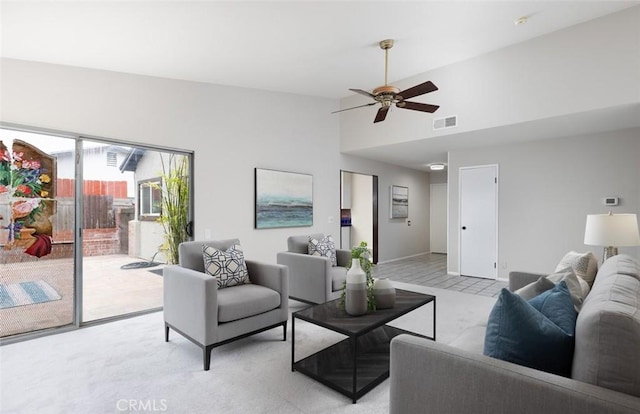 living room with visible vents, ceiling fan, lofted ceiling, and light carpet