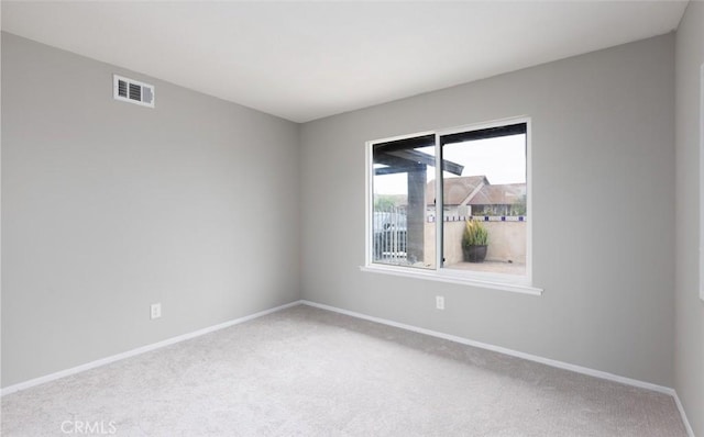 unfurnished room with visible vents, carpet, and baseboards