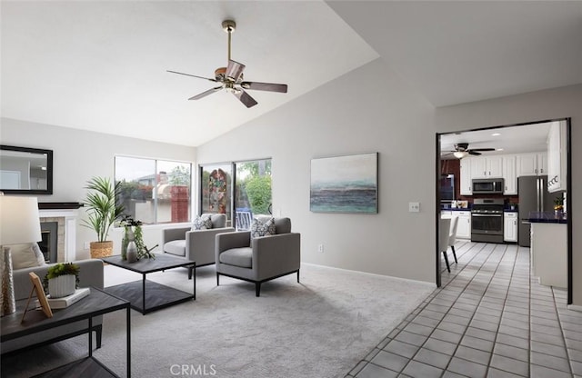 living room with baseboards, high vaulted ceiling, light colored carpet, a tile fireplace, and a ceiling fan
