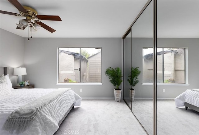 bedroom with a ceiling fan, baseboards, carpet, and a closet