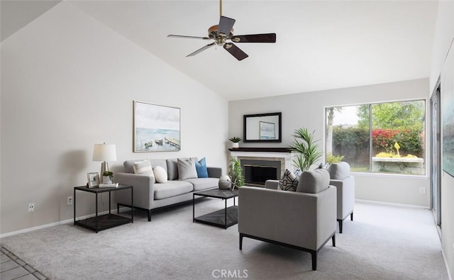 living area featuring a ceiling fan, baseboards, carpet, and a fireplace