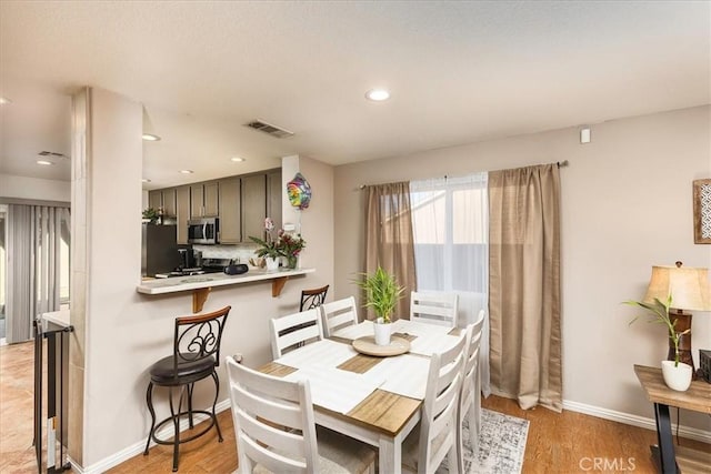 dining space with recessed lighting, visible vents, light wood-style flooring, and baseboards