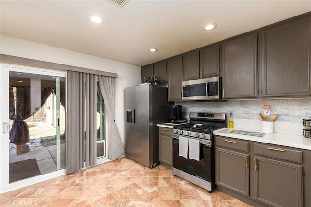 kitchen with recessed lighting, appliances with stainless steel finishes, light countertops, and decorative backsplash