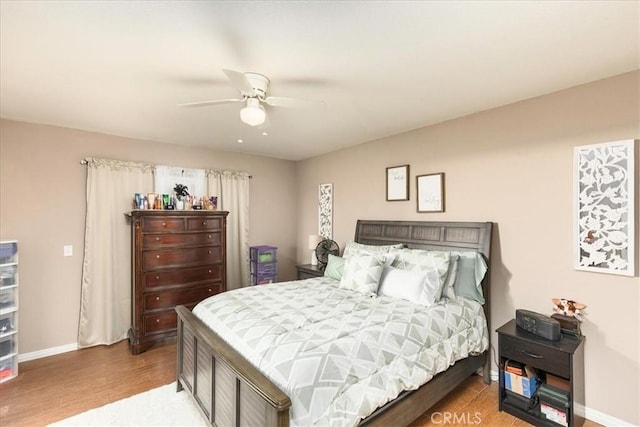 bedroom with wood finished floors, ceiling fan, and baseboards