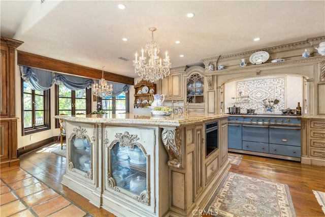 1015 Wild Oats Way, Templeton, CA 93465 - kitchen featuring recessed lighting, light stone countertops, glass insert cabinets, a chandelier, and a center island