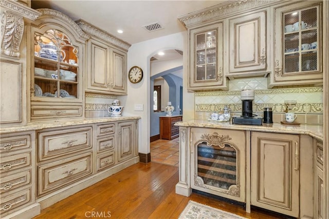 1015 Wild Oats Way, Templeton, CA 93465 - bar featuring visible vents, light wood-type flooring, decorative backsplash, and arched walkways