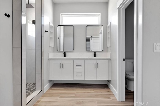 full bath featuring a sink, a stall shower, and toilet