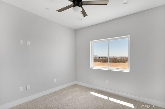 carpeted empty room with baseboards and ceiling fan
