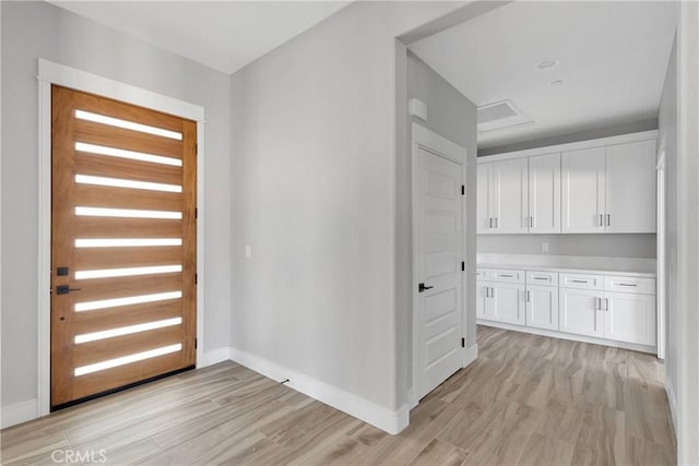 foyer with baseboards and light wood-style flooring