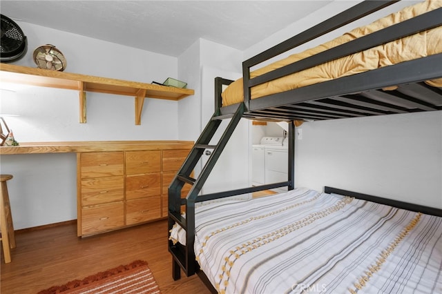 bedroom with wood finished floors and separate washer and dryer