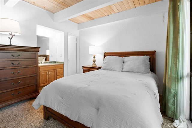 carpeted bedroom with beam ceiling, ensuite bath, and wood ceiling