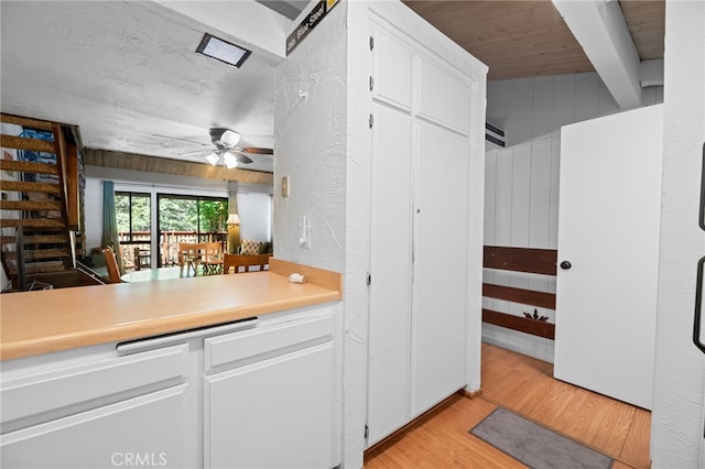 kitchen featuring wood ceiling, light wood-style floors, light countertops, white cabinets, and a ceiling fan