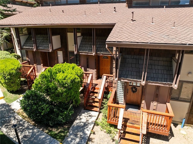 view of exterior entry with a shingled roof