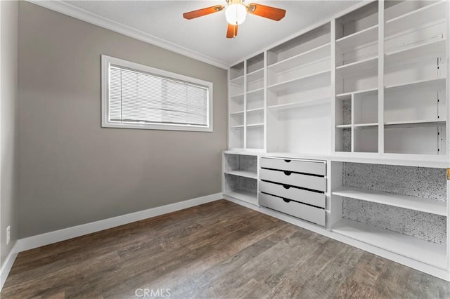 interior space with ornamental molding, a ceiling fan, dark wood-style flooring, and baseboards
