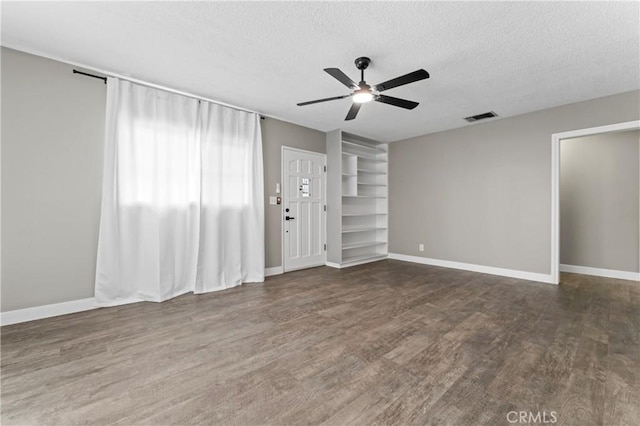 unfurnished living room with wood finished floors, ceiling fan, baseboards, visible vents, and a textured ceiling