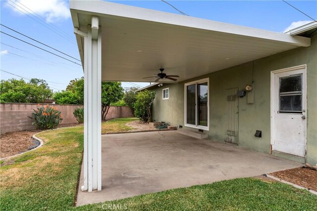 view of patio featuring fence, a carport, and a ceiling fan
