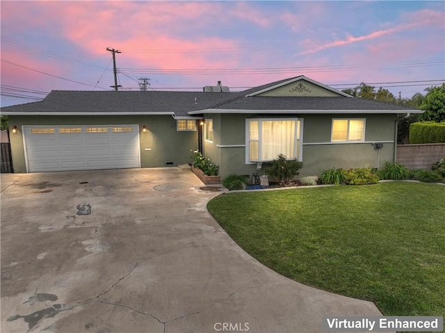 ranch-style house with a front yard, concrete driveway, a garage, and stucco siding