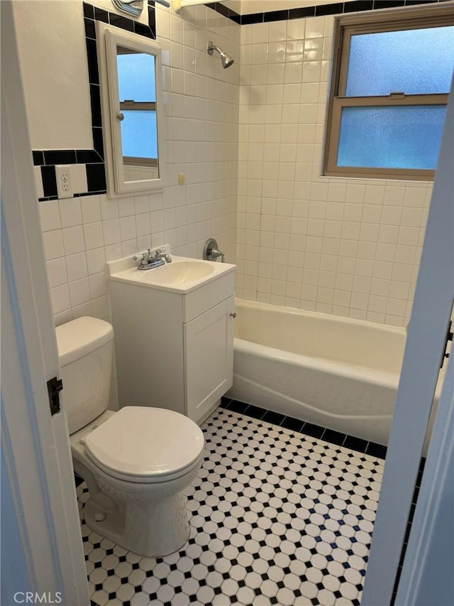 full bathroom featuring tile walls, vanity, shower / bathtub combination, tile patterned floors, and toilet