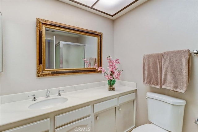bathroom with toilet, a stall shower, and vanity