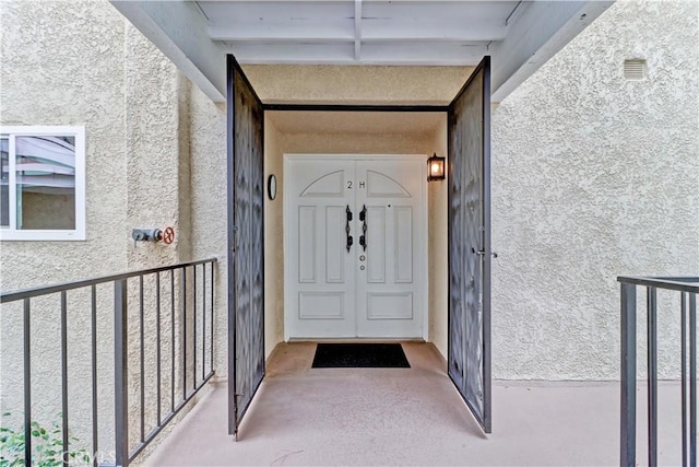 property entrance with visible vents and stucco siding