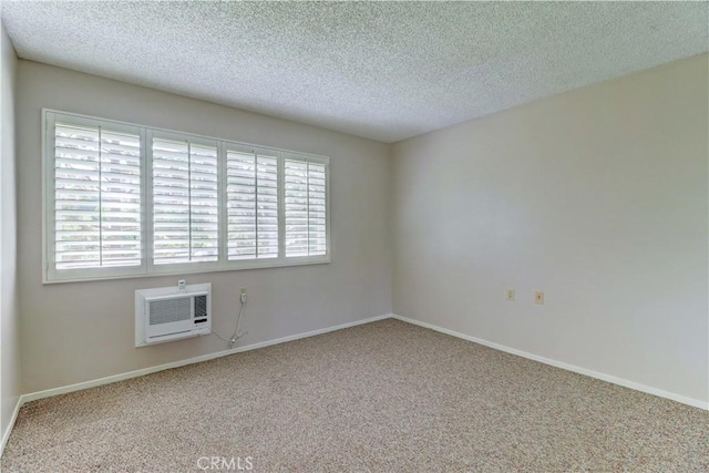carpeted empty room with plenty of natural light, a textured ceiling, and an AC wall unit
