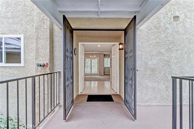 doorway to property featuring stucco siding and visible vents
