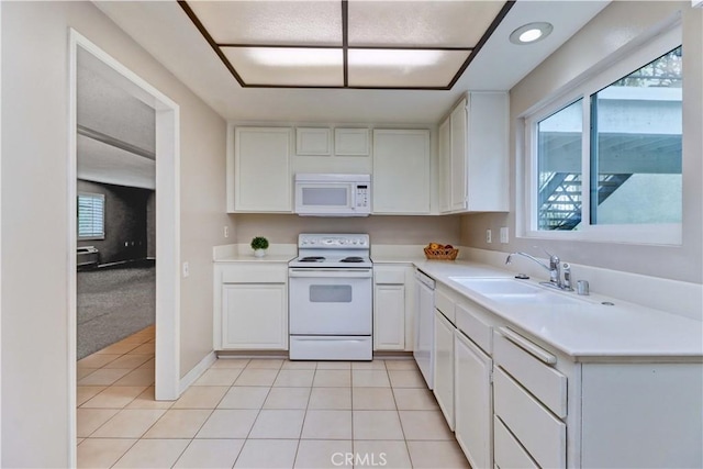 kitchen featuring white cabinetry, white appliances, light countertops, and a sink