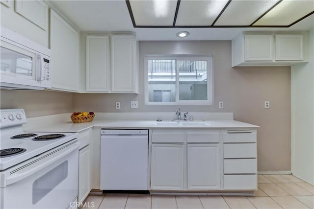 kitchen with a sink, light tile patterned floors, white appliances, white cabinetry, and light countertops