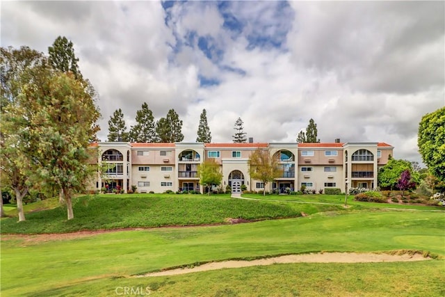 view of property's community featuring golf course view and a yard