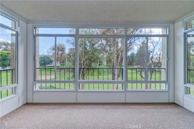 unfurnished sunroom with a textured ceiling and carpet flooring