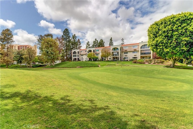 surrounding community featuring a yard and view of golf course