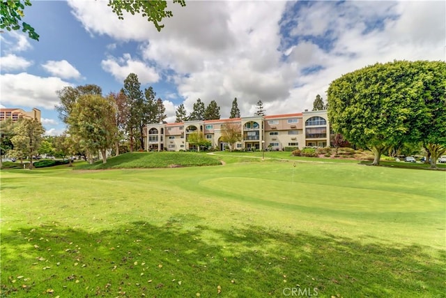 surrounding community featuring a yard and view of golf course