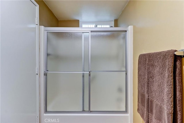 bathroom with a shower with door