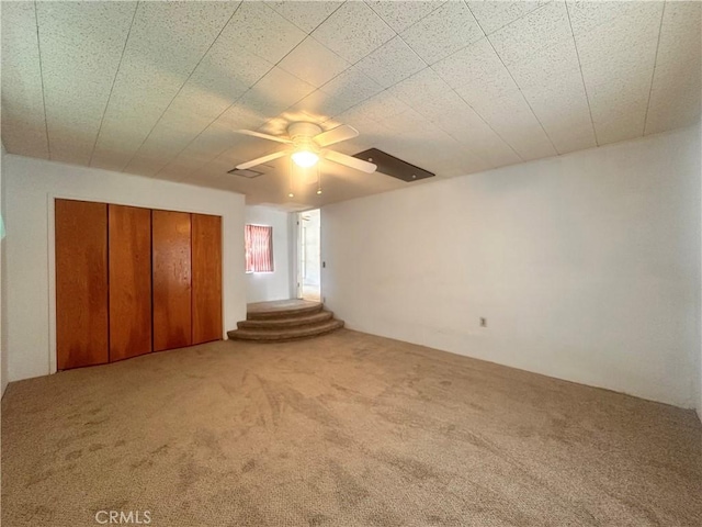 unfurnished bedroom featuring a ceiling fan, carpet flooring, and a closet