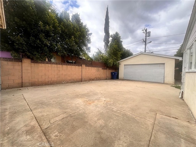 detached garage featuring fence