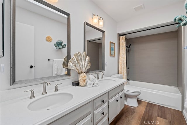 bathroom featuring shower / bath combo, wood finished floors, toilet, and a sink