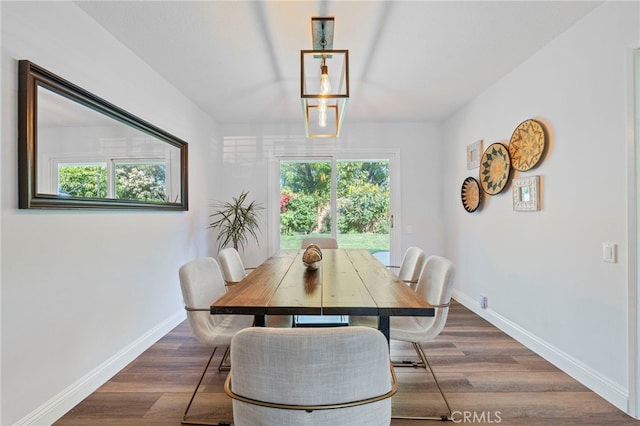 dining area featuring dark wood-style flooring and baseboards