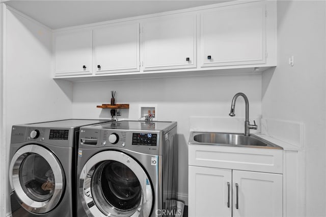 laundry area featuring washer and clothes dryer, cabinet space, and a sink