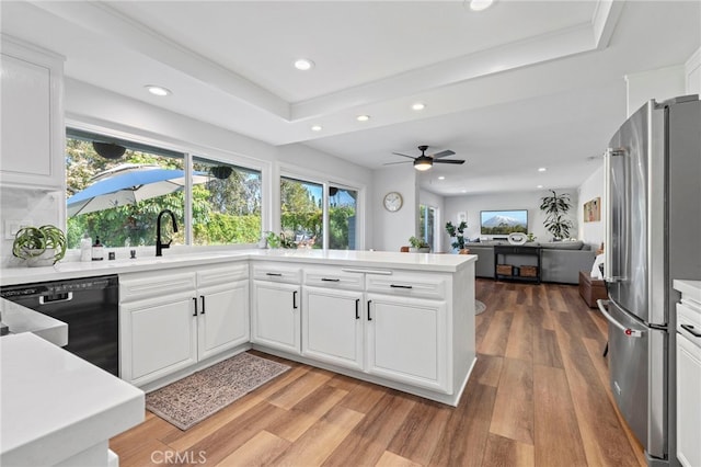 kitchen with recessed lighting, freestanding refrigerator, black dishwasher, a sink, and a peninsula