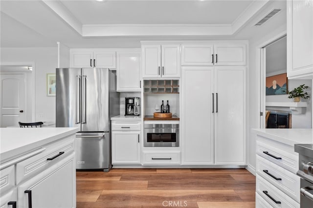 kitchen with visible vents, appliances with stainless steel finishes, a raised ceiling, and light countertops