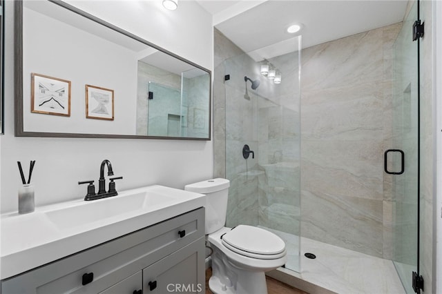 full bathroom with a shower stall, toilet, and vanity