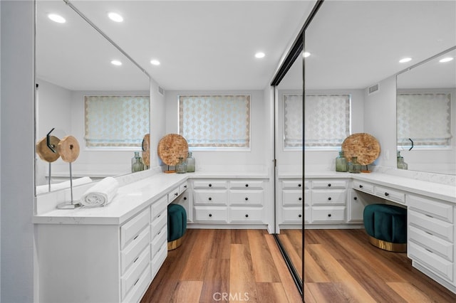 office featuring recessed lighting, wood finished floors, and built in desk
