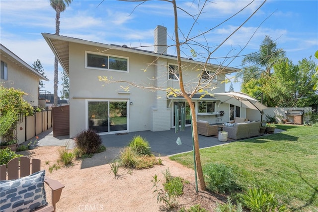 back of property with a patio area, a yard, outdoor lounge area, stucco siding, and fence
