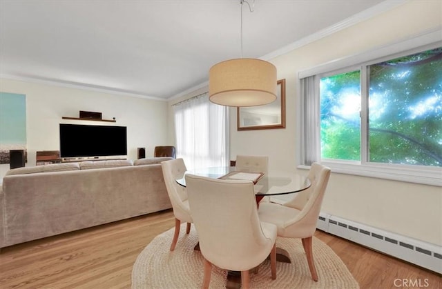 11767 W Sunset Blvd Unit 206, Los Angeles, CA 90049 - dining area featuring baseboard heating, crown molding, plenty of natural light, and light wood-style flooring