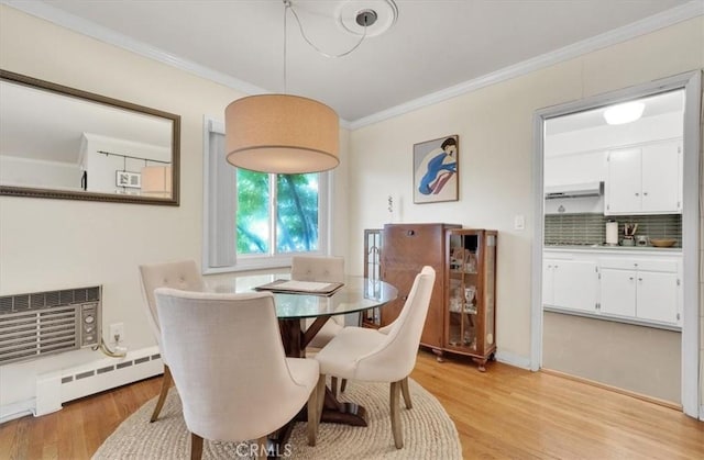 11767 W Sunset Blvd Unit 206, Los Angeles, CA 90049 - dining room featuring crown molding, light wood-style flooring, an AC wall unit, and baseboard heating
