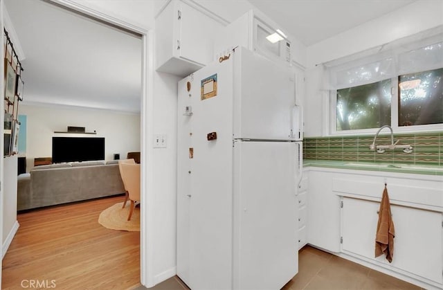 11767 W Sunset Blvd Unit 206, Los Angeles, CA 90049 - kitchen with freestanding refrigerator, a sink, white cabinetry, and light countertops