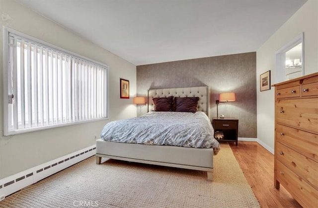11767 W Sunset Blvd Unit 206, Los Angeles, CA 90049 - bedroom featuring baseboard heating, wood finished floors, and baseboards