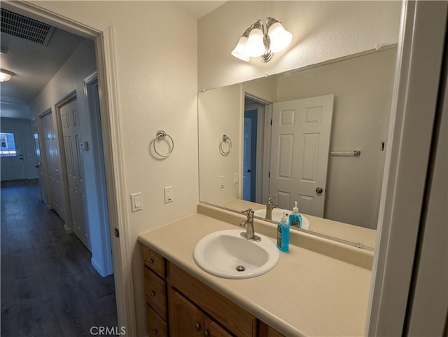 bathroom featuring vanity, visible vents, and wood finished floors