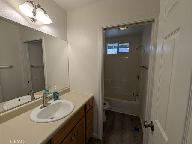 full bathroom featuring toilet, vanity, tub / shower combination, and wood finished floors